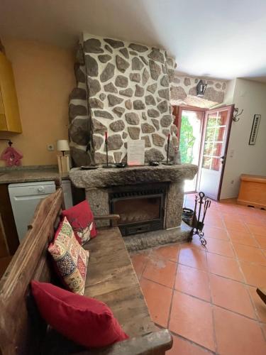 a living room with a stone fireplace and a couch at Casa do Palheiro de Cima in Geres