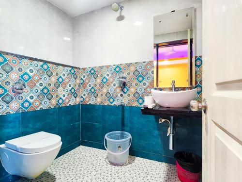a bathroom with a sink and a toilet and a mirror at Casa Salvador in Calangute