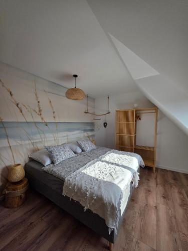 a bedroom with a large bed in a room at Zakatek Mala-apartamenty nad jeziorem in Kołczewo