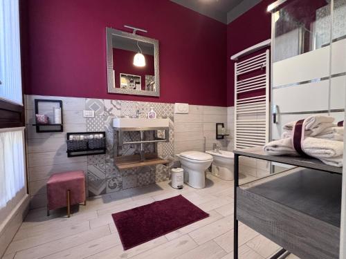 a bathroom with a purple wall with a toilet at Casa di Silvia city center in Verona