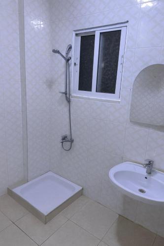 a white bathroom with a sink and a shower at Nice Apartment with Sea View in Aqaba