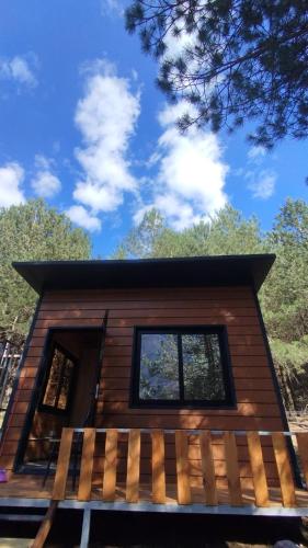 a log cabin with a porch and a blue sky at Vruçaj' s Cabin in Bogë