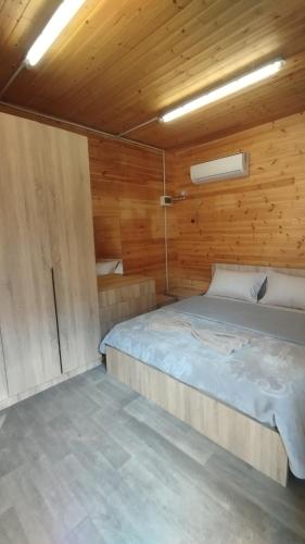 a bedroom with a bed in a wooden cabin at Vruçaj' s Cabin in Bogë
