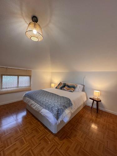 a bedroom with a large bed and a lamp at Lucky Jack in Jardim do Mar