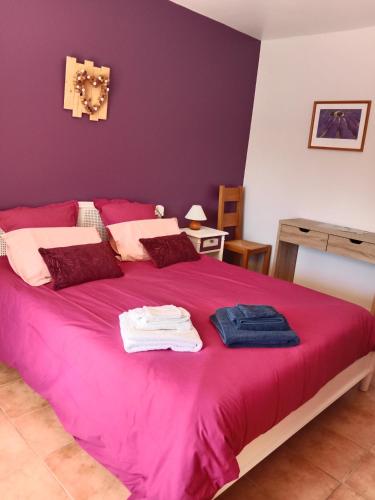 a bedroom with a pink bed with towels on it at la Farigoulette in Lorgues