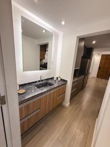 a bathroom with a sink and a large mirror at Aura Urbana Apartment in San Juan