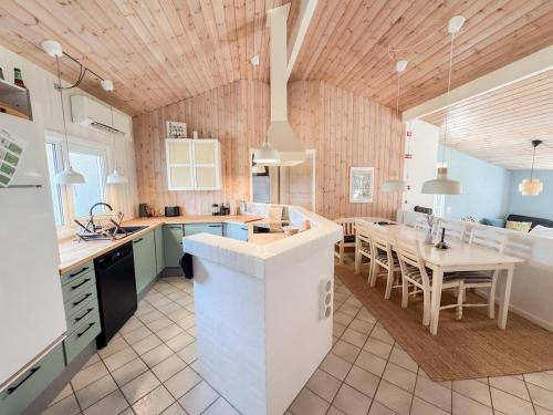 a kitchen with a table and a dining room at Klitrosen Coastal Hideout in Thisted