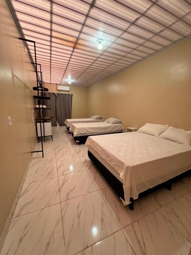 a room with three beds and a staircase in it at Pousada G3 in Presidente Figueiredo