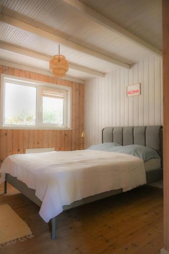 a bedroom with a large bed in a room at Klitrosen Coastal Hideout in Thisted