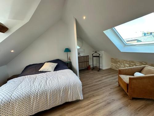 a bedroom with a bed and a couch in a attic at Manava Etretat Sea ViewHouse in Étretat