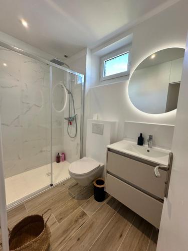 a bathroom with a toilet sink and a shower at Manava Etretat Sea ViewHouse in Étretat