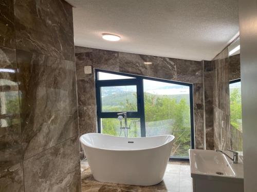 a bathroom with a large tub and a window at Stone Villa in Zagrađe