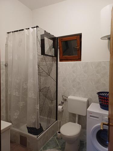 a bathroom with a shower curtain and a toilet at Apartman Čerkez in Stolac