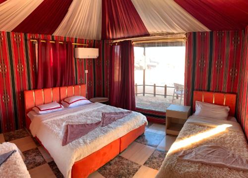 a bedroom with a bed and a window at Hillawi Private Desert Camp in Aqaba