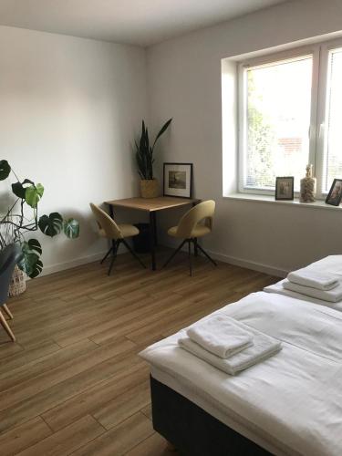 a bedroom with a bed and a table and a window at Apartamenty Tarcal in Tarcal