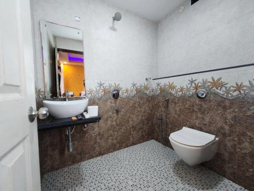 a bathroom with a sink and a toilet and a mirror at Veronica By The Beach Calangute in Calangute