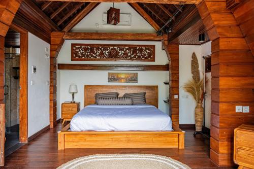 a bedroom with a bed in a room with wooden ceilings at Villa AMPO unique Gazebo Flat in Munggu