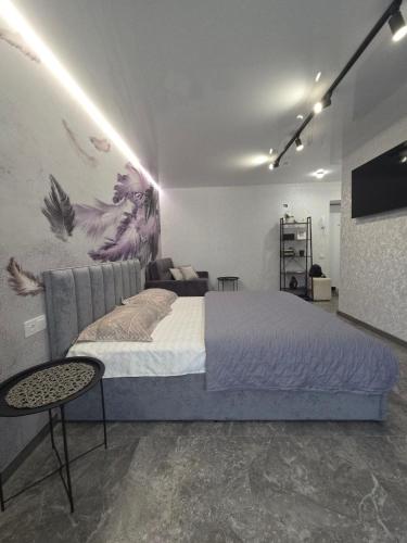 a bedroom with a large bed and a tv at Апартаменты возле отеля Украина in Chernihiv
