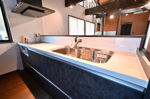 a kitchen with a sink and a counter top at Manabi-WAN Takayama in Takayama