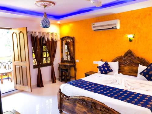 a bedroom with a bed and a yellow wall at Veronica By The Beach Calangute in Calangute
