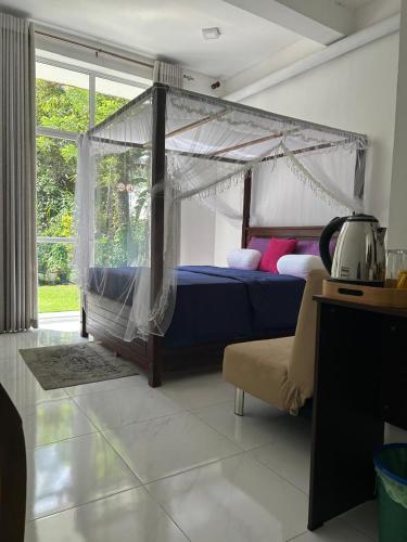 a bedroom with a bed with a canopy at Ella Thenulya in Ella