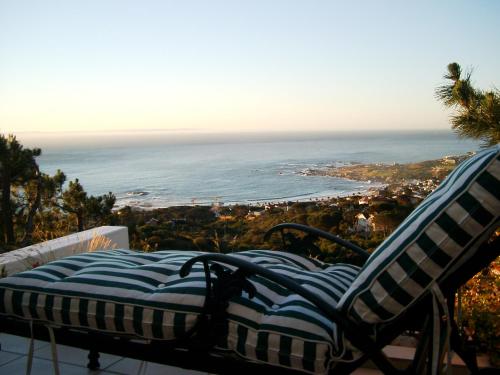 a chair on a balcony with a view of the ocean at Camps Bay Villa in Cape Town