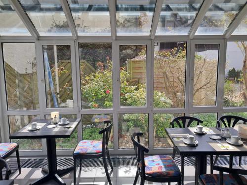 a room with two tables and chairs in front of a window at Gästehaus Linde, Hotel garni in Konstanz