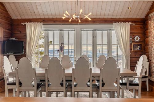 a dining room with a table and chairs and a television at Eksklusiv tømmerhytte Spa Panoramautsikt in Aurdal