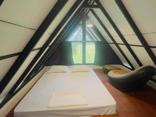 a bed in a small room with a window at Rainforest Mountain Escape - Lankagama in Deniyaya