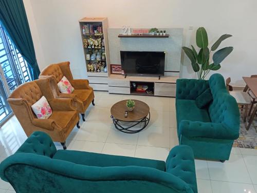 a living room with couches and a tv at Seri Jerantut Homestay in Jerantut