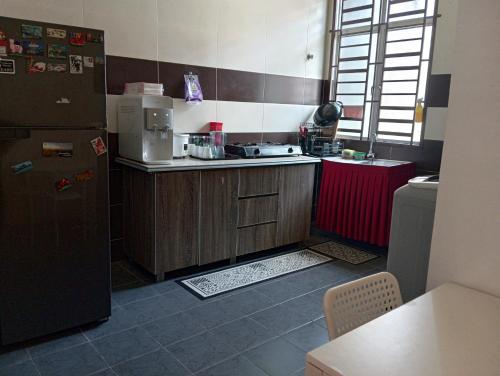 a small kitchen with a refrigerator and a sink at Seri Jerantut Homestay in Jerantut