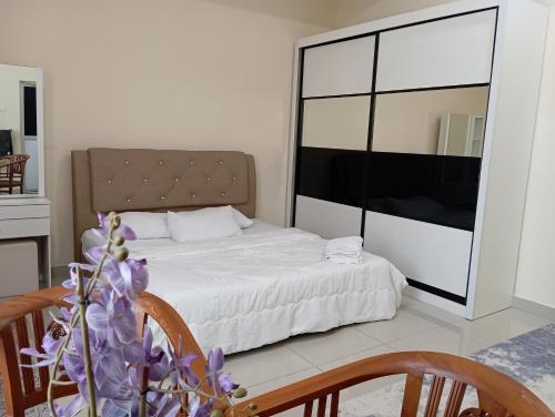 a bedroom with a bed and a table and chairs at Seri Jerantut Homestay in Jerantut