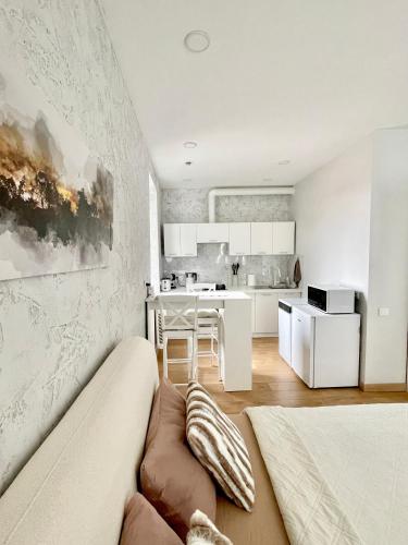 a living room with a couch and a kitchen at Rami studio apartment in Panevėžys