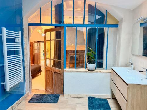 a bathroom with a large window and a sink at Le jardin de Grignan in Réauville
