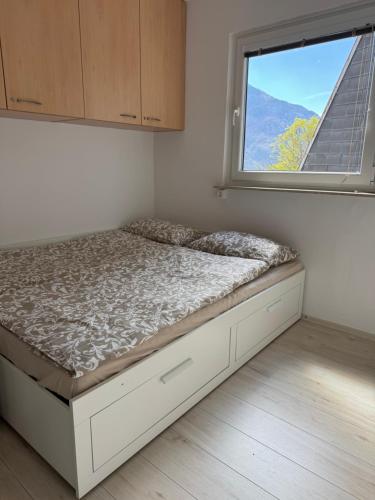 a bed in a room with a window at Apartment Planika Bovec in Bovec