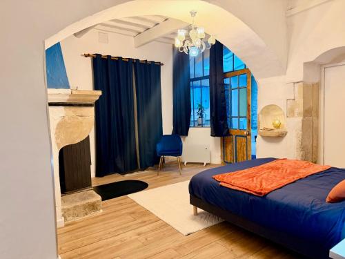 a bedroom with a bed and a fireplace at Le jardin de Grignan in Réauville