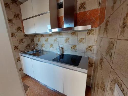 a kitchen with white cabinets and a blue sink at Agata Agnese Homes in Carlazzo