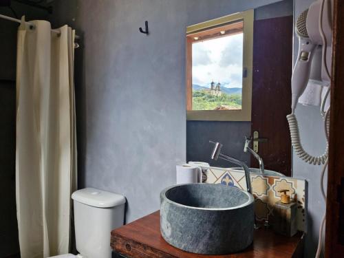 a bathroom with a sink and a tub at Pousada Memórias de Minas in Ouro Preto