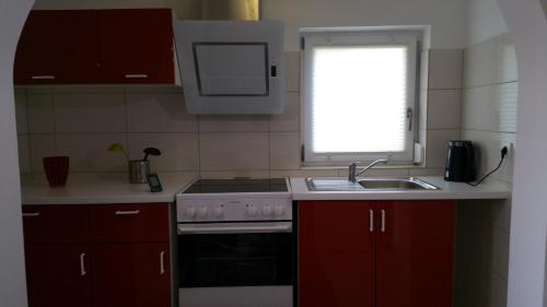 a kitchen with a stove and a sink and a window at Ferienwohnung Blick auf die Berge in Pidingerau