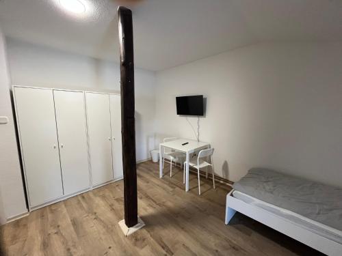 a bedroom with a bed and a table and a tv at Zweibettzimmer nah der A7 Tarp in Jerrishoe