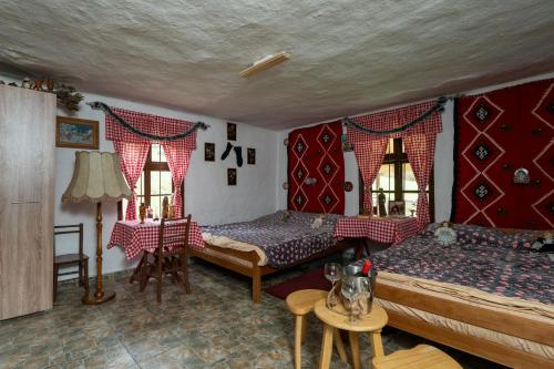 a bedroom with two beds and a table at Kmetova Bajka in Janja