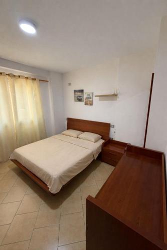 a bedroom with a bed and a table in it at Aldi APARTMENTS in Lezhë
