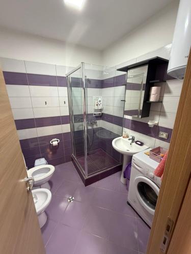 a bathroom with a shower and a toilet and a sink at Aldi APARTMENTS in Lezhë