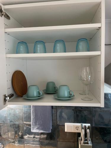 a shelf with blue dishes and a wine glass at Bo's 3Eins in Schwäbisch Hall