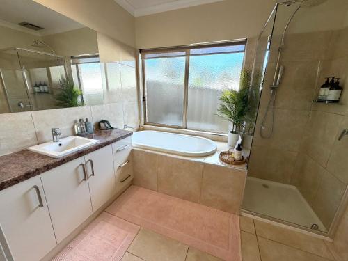 a bathroom with a tub and a sink and a shower at The Nest at Forest Lake - Stylish Guest Suite in Kangaroo Flat