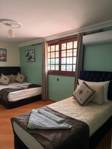 a bedroom with two beds and a window at Gite jnanefes in El Jadida