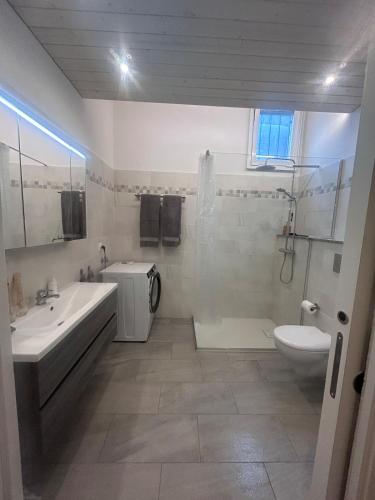 a bathroom with a tub and a sink and a toilet at Holiday accomodation appartamento in seminterrato in Coglio