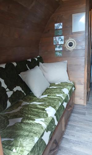 a bed in a wooden room with at La Colline Aux Cabanes in Espaly-Saint-Marcel