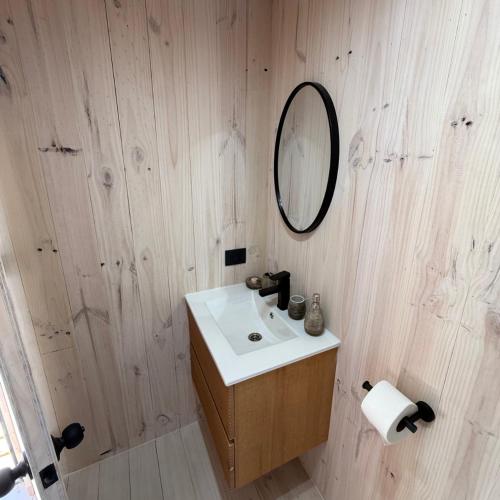a bathroom with a sink and a mirror on the wall at Costa Lodge Pichilemu in Pichilemu