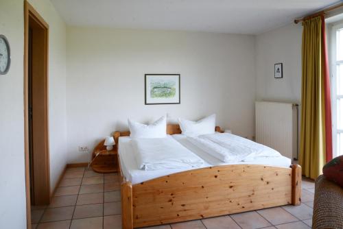 a bedroom with a wooden bed with white sheets at Landhaus am Esch in Warendorf